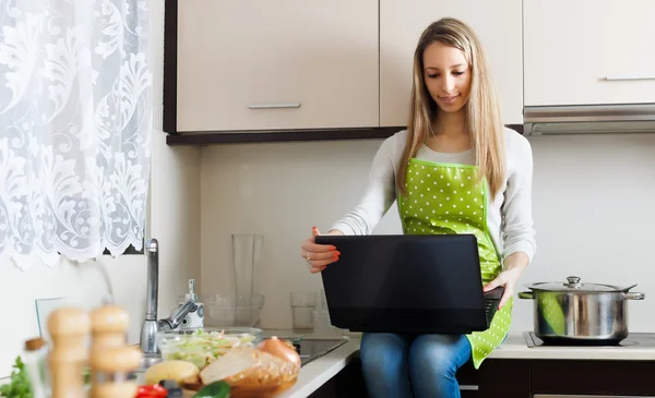 Ordinary girl in apron cooking with notebook — Stock Photo, Image