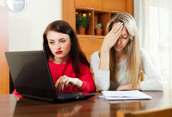 Szomorú nők pénzügyi dokumentumok és laptop — Stock Fotó