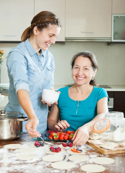 Duas mulheres fazendo vareniki doce com bagas — Fotografia de Stock