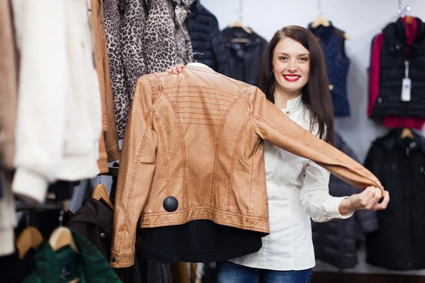 Женщина выбирает куртку в бутике — стоковое фото