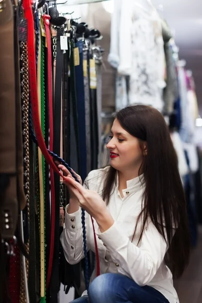 Vrouw kiezen riem bij shop — Stockfoto