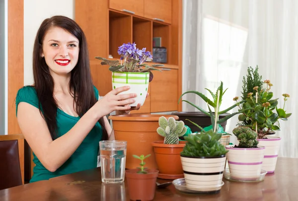 Chica trabajando con viola flores — Foto de Stock