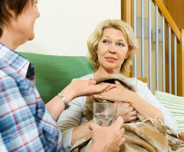 Two aged women with pill and glass of water — Stock Photo, Image