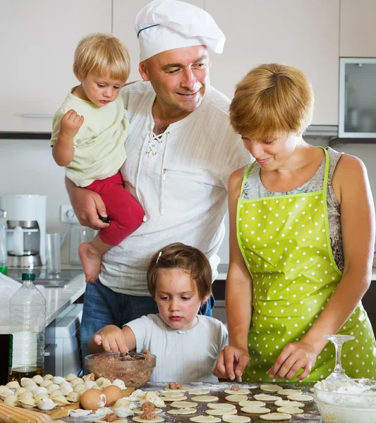 Família feliz de quatro fazendo bolinhos de carne — Fotografia de Stock