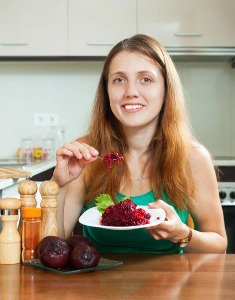 Vrouw in het groen eten gekookte bieten — Stockfoto