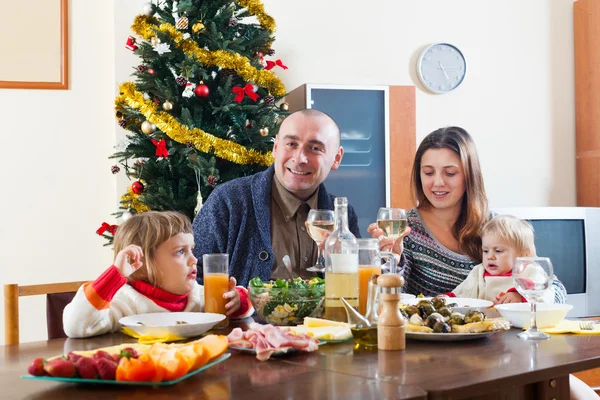 Glückliche Familie am Weihnachtstisch — Stockfoto