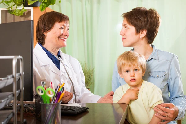 Mãe com bebê conversando com médico na clínica — Fotografia de Stock