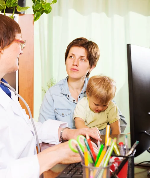 Mãe com bebê ouvindo médico amigável — Fotografia de Stock