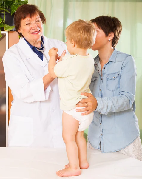 Mature  doctor examing baby  at clinic — Stock Photo, Image