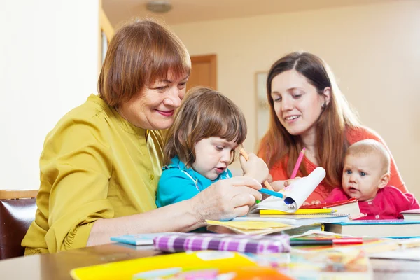 Nonna con figlia e nipoti che disegnano a casa — Foto Stock