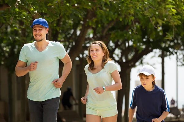 Família feliz com criança correndo no parque — Fotografia de Stock