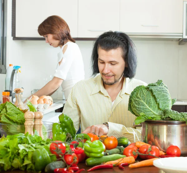Frau und Mann mit Gemüse in der Küche — Stockfoto