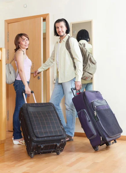 Two tourists with luggage near door — Stock Photo, Image