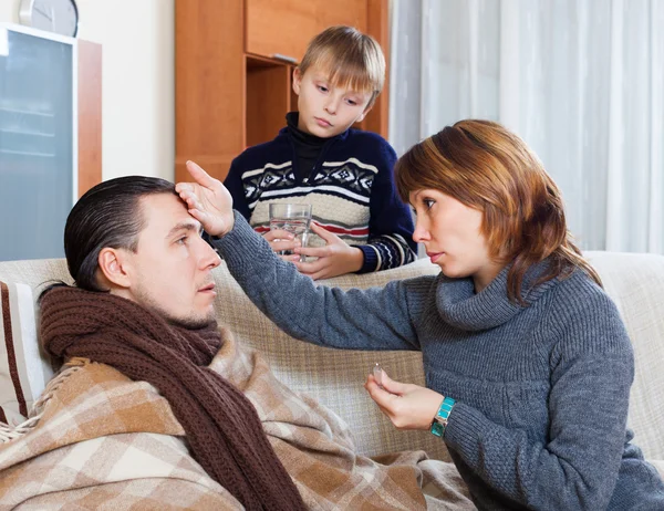 Mulher e filho cuidando do homem da doença — Fotografia de Stock