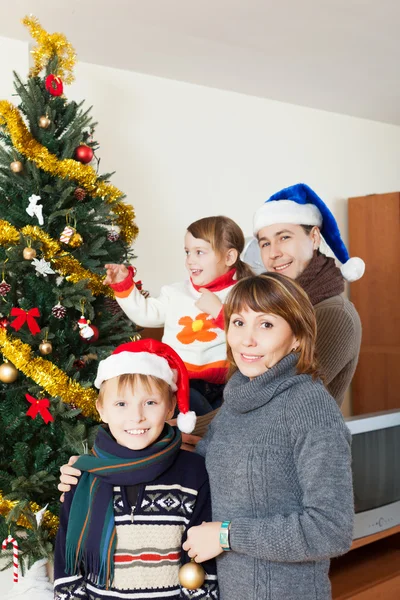 Família feliz de quatro com árvore de Natal — Fotografia de Stock