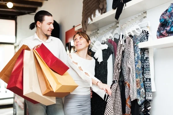 Coppia che sceglie i vestiti al negozio — Foto Stock