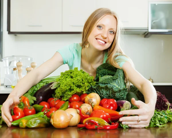 Happy woman with pile of vegetables — Stock Photo, Image