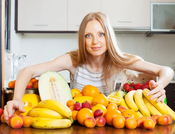 Woman with heap of fruits — Stock Photo, Image