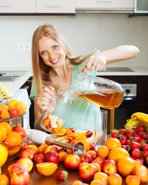Jente som lager ferske drikker med frukt – stockfoto