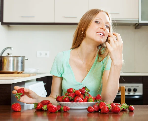 Mujer comiendo fresa en casa cocina —  Fotos de Stock