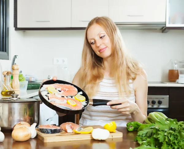 Leende kvinna matlagning laxfiskar — Stockfoto