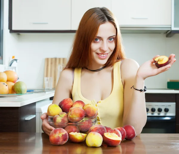 Positive houswife holding peaches — Stock Photo, Image