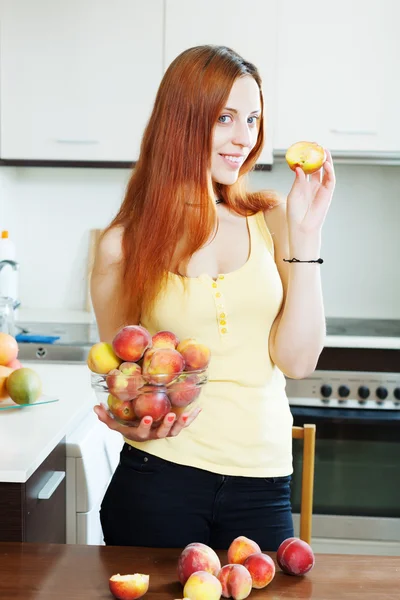 Pretty long-haired woman holding peaches — Stock Photo, Image