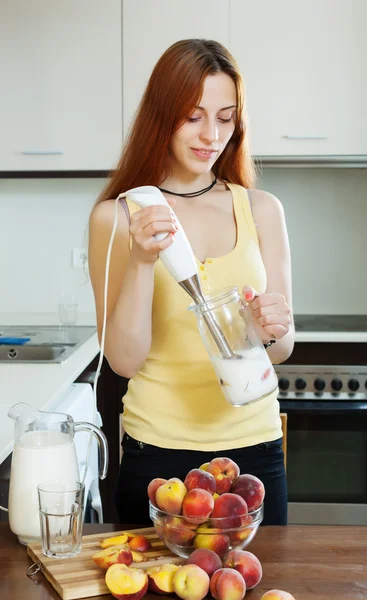 Vrouw koken dranken van perziken — Stockfoto