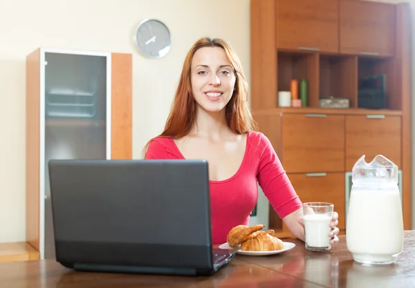 Pssitive happy woman in red using laptop during breakfast at hom — Stock Photo, Image