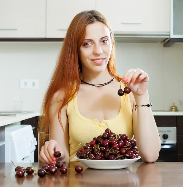 Sorrindo menina de cabelos longos comendo cereja — Fotografia de Stock