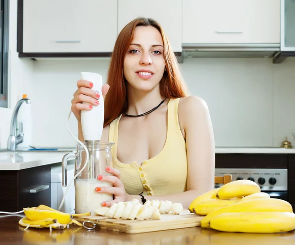 バナナと牛乳からの飲料を作る女性 — ストック写真