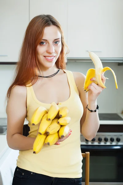 Long-haired girl eating banana — Stock Photo, Image