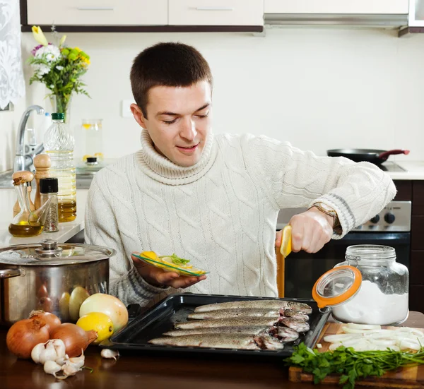 Ragazzo cucinare il pesce con limone in teglia — Foto Stock