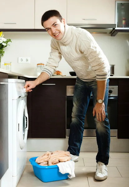 Man die kleren in de wasmachine doet — Stockfoto