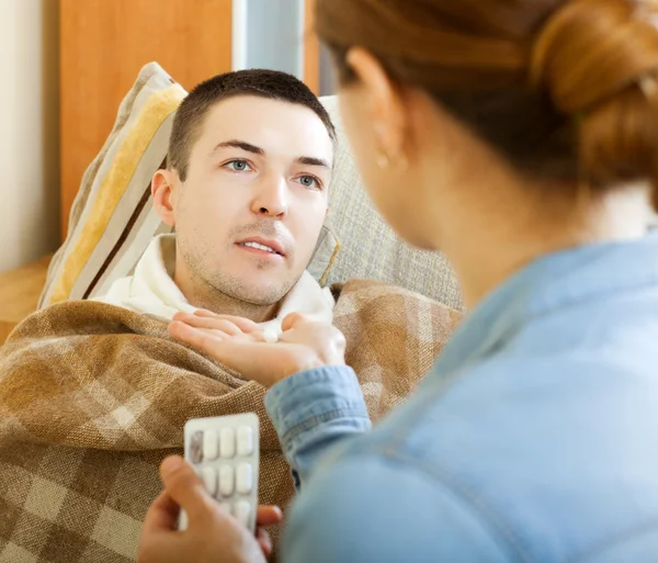 Wife giving pills to diseased man — Stock Photo, Image