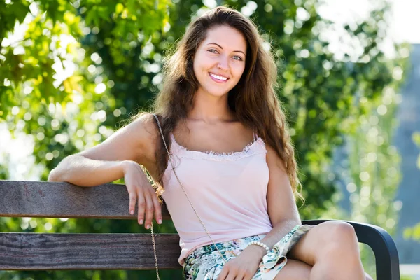 Junge Frau sitzt auf Bank — Stockfoto