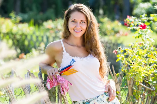 Menina em rosas planta no jardim — Fotografia de Stock