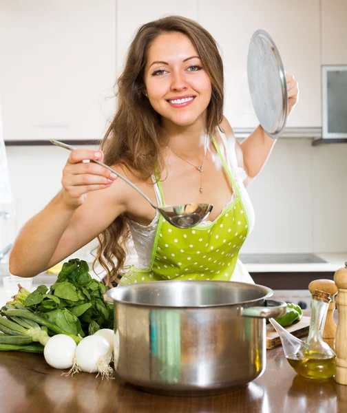 Mujer cocinando sopa en la cocina — Foto de Stock