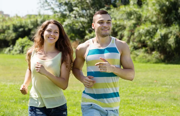 Feliz jovem casal correndo ao ar livre — Fotografia de Stock