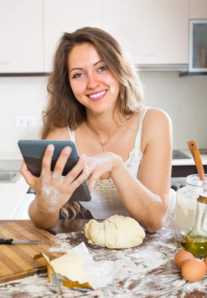 Домохозяйка готовит с планшетом дома — стоковое фото