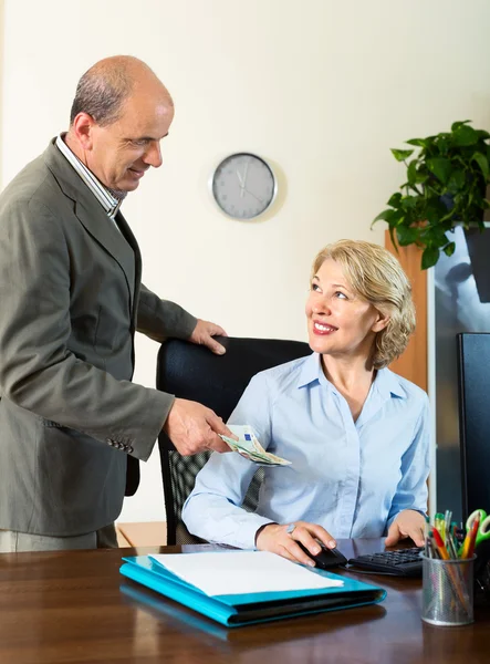 Aged male accountant  paying salary in cash — Stock Photo, Image