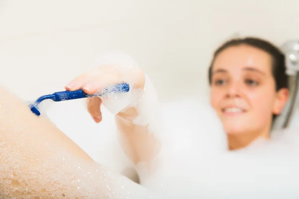 Mujer joven afeitándose las piernas en baño —  Fotos de Stock