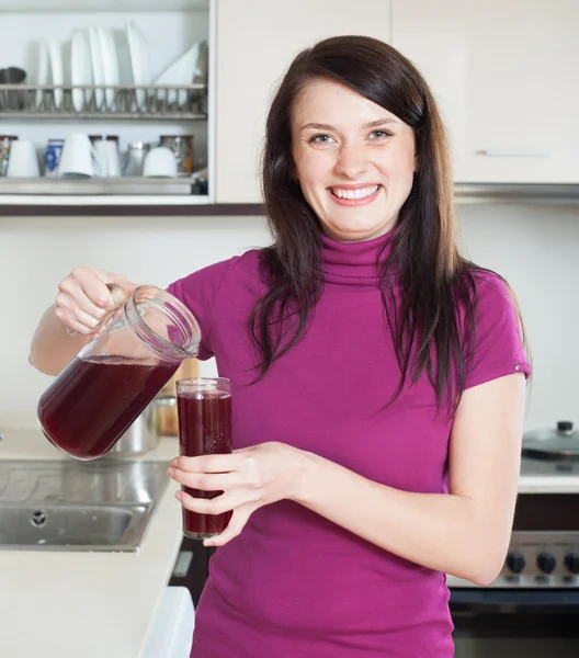 Mulher feliz derramando frutas-bebida ou suco de jarro — Fotografia de Stock