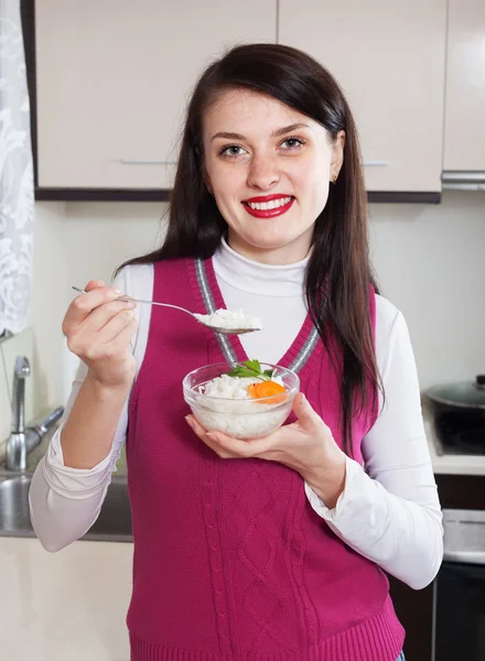 Mulher sorridente comendo arroz cozido — Fotografia de Stock