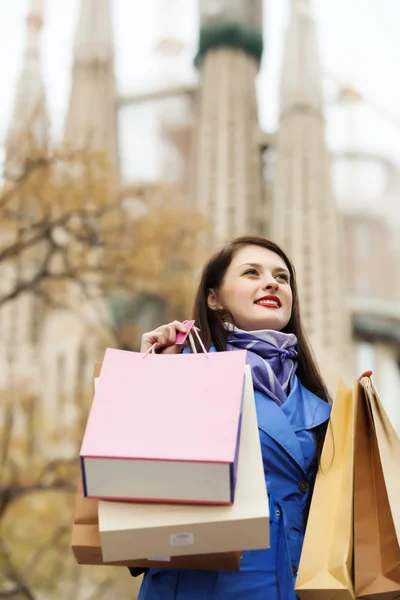 Mujer con bolsas de compras contra Sagrada familia — Foto de Stock
