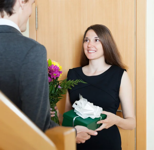 Girl giving flowers and gift — Stock Photo, Image