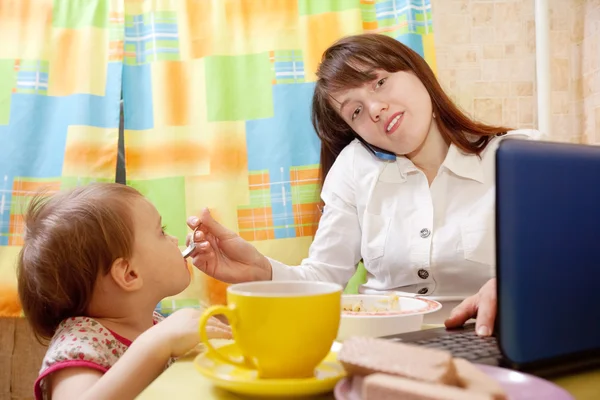 Businesswoman feeding baby — Stock Photo, Image