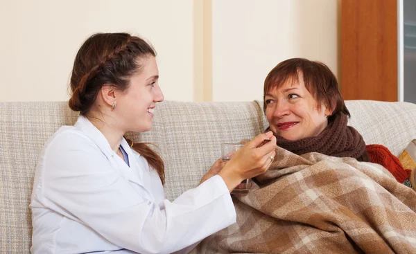 Nurse caring for unwell mature woman — Stock Photo, Image