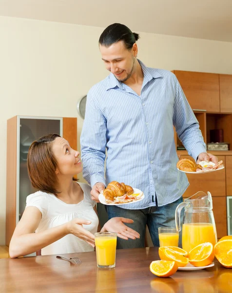 Lächelndes Paar frühstückt mit Saft — Stockfoto
