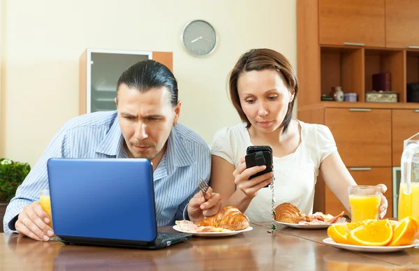Happy casual couple using electronic devices — Stock Photo, Image